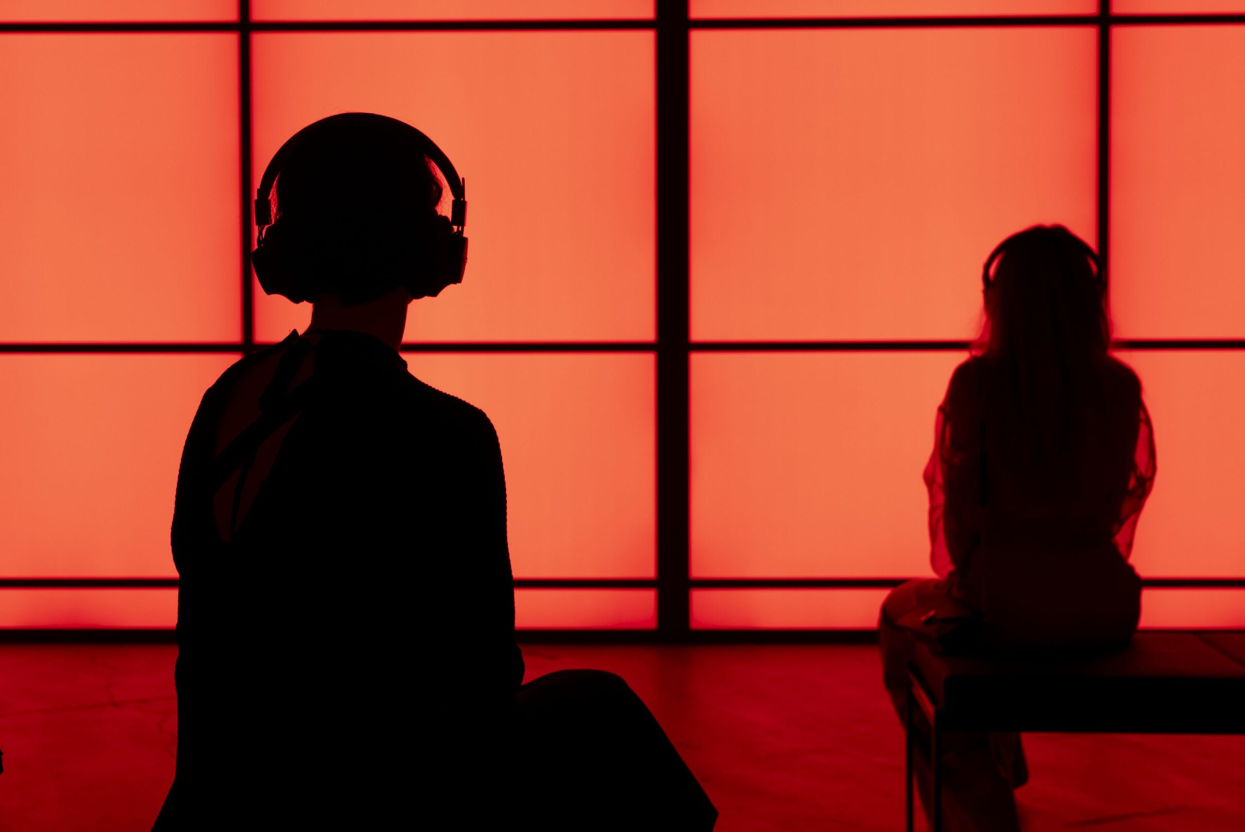 Two spectators sitting in front of the light panels